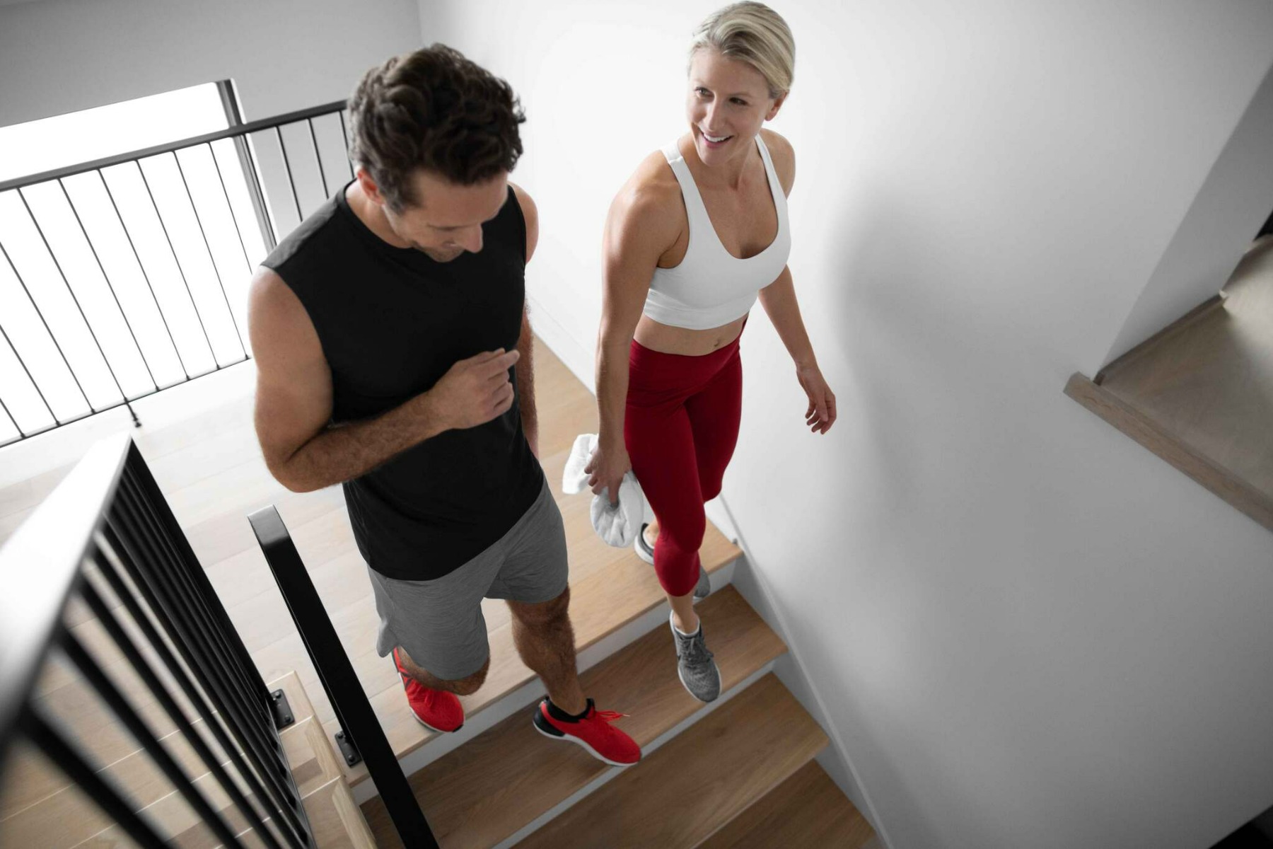 Mujer y hombre sanos con ropa deportiva corriendo entre sí dando un alto  cinco mientras entrenan en el ejercicio en el gimnasio